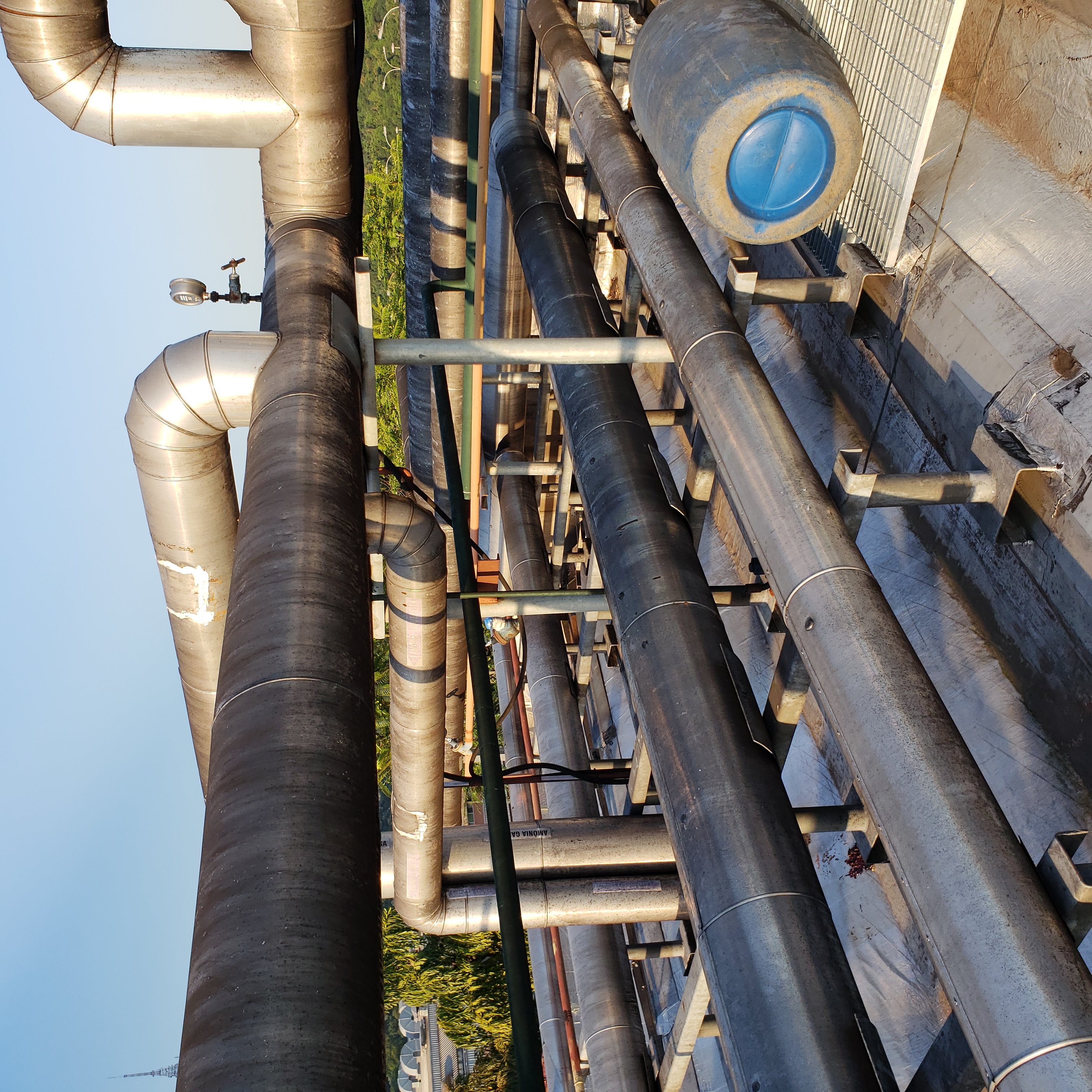 Tubulações industriais isoladas em telhado de planta